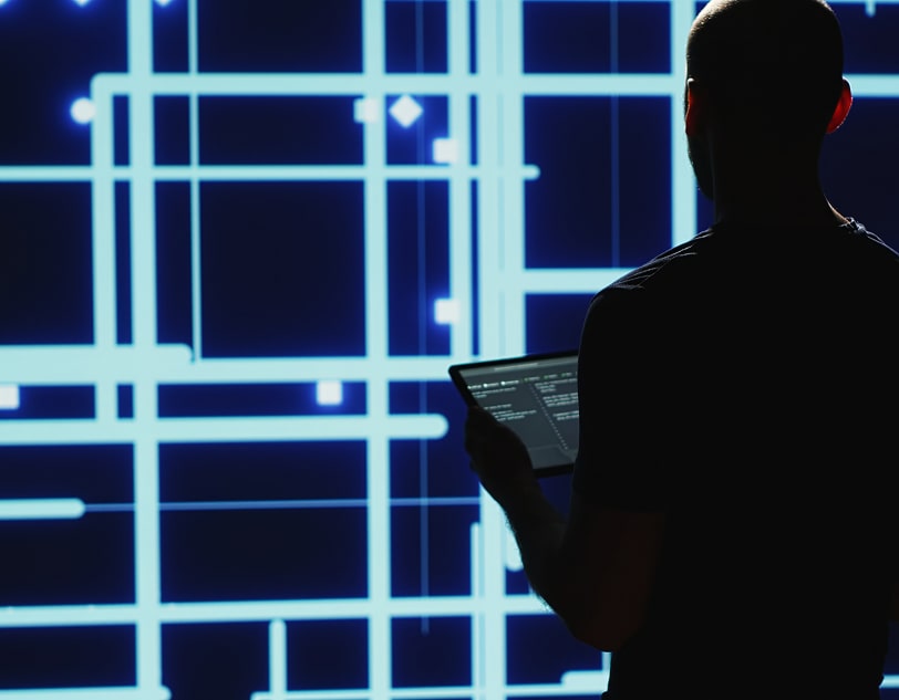 Silhouetted figure with tablet, digital grid background.