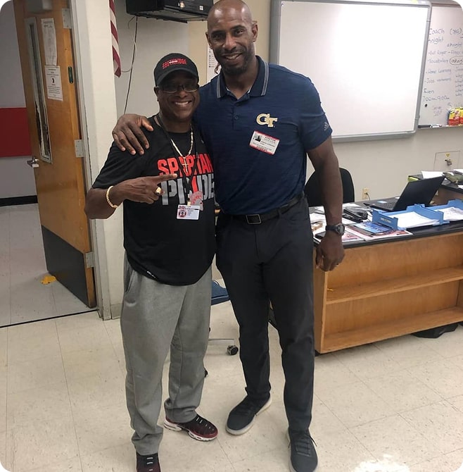 Two staff members in office, Spartan Pride shirt